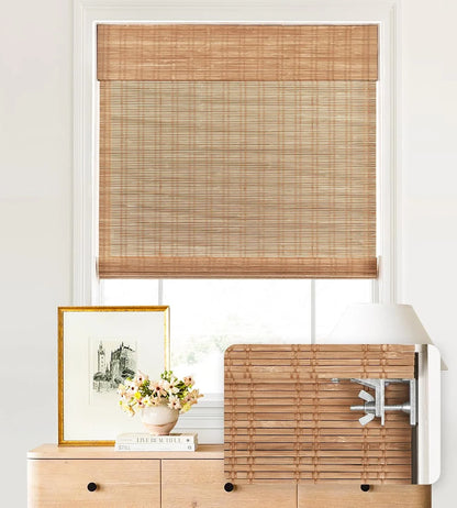 Bamboo window blinds with a decorative frame and flowers on a white wall.